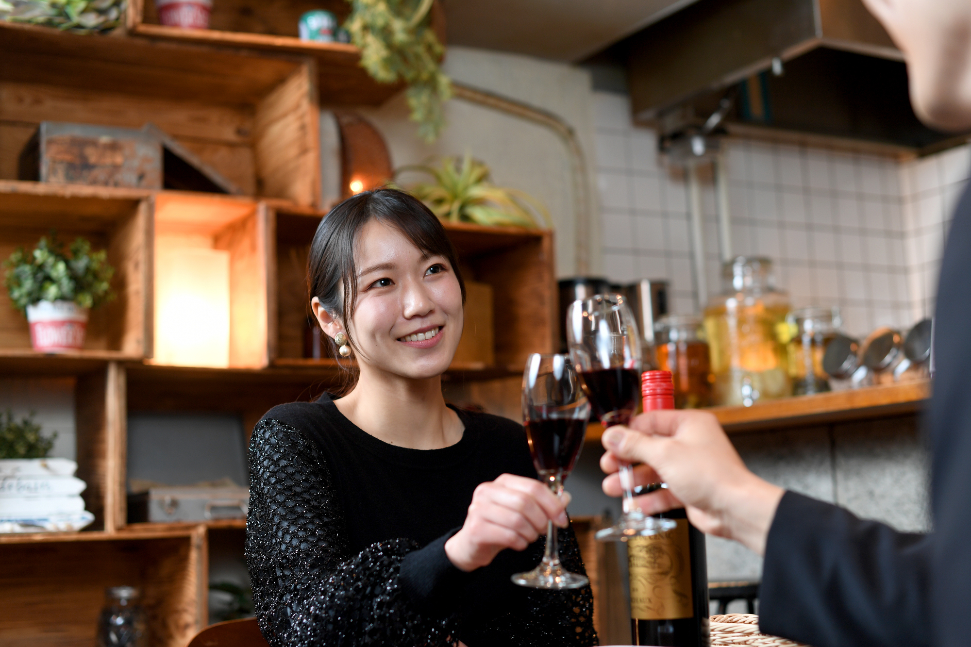 明るい店内でグラスを合わせて交流を楽しむ女性